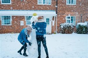 two students making snowman 